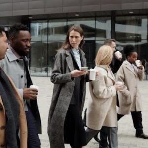 A group of diverse business professionals enjoying a coffee break outdoors in the city.